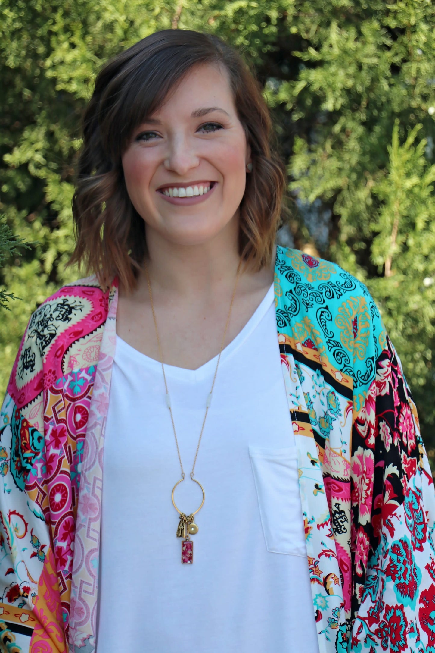 Alex is wearing the Memory Flower Diamond Hoop Charm Necklace -long  gold necklace using pink flowers with charms dangling >