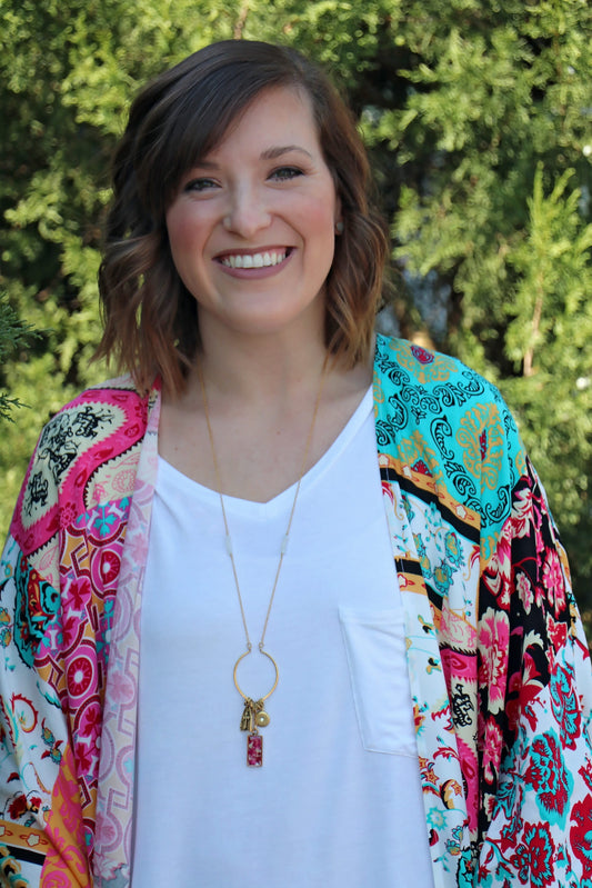 Alex is wearing the Memory Flower Diamond Hoop Charm Necklace -long  gold necklace using pink flowers with charms dangling >